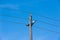 Old simple rural wood electrical pole on blue sky