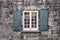 Old simple window with opened wooden green shutters.