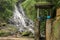 Old sluice on the river with a waterfall in the background. Ston