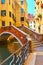 Old small arch bridge over canal in Venice