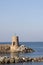 Old small lighthouse and stone wave breakers of Recco on a sunny summer day.
