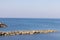 Old small lighthouse and stone wave breakers of Recco on a sunny summer day.