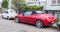 Old small red sport car Alfa Romeo Spider parked left side view