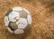 Old soccer ball on Dry and cracked ground texture .