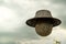 old soccer ball wearing a bamboo hat floating in the air sky background