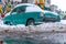 Old Soviet car Volga. Turquoise retro car covered with snow. GAZ-21 on the street