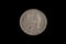 An old Spanish five peseta coin on black