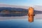 Old Spanish windmill in lagoon Orbetello on peninsula Argentario at sunise. Italy