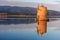 Old Spanish windmill in lagoon Orbetello on peninsula Argentario at sunise. Italy