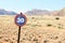 Old speed road sign in desert and mountain landscape