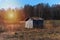 Old spooky house on the land. Wooden house of the barren land. Lonely old gloomy house under the dark trees.Sunrise Scenic retro