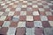 Old square tiles in a checkerboard pattern lying
