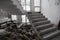 An old staircase in an abandoned house with an interior destroyed by vandals