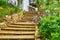 Old stairs footpath lined with flowers and rocks leading to house on a hill