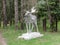 Old statue of an Elk with antlers in the woods.
