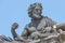 Old statute of poet or writer with book, Bible, writing something at historical center of Dresden, Germany, at blue sky