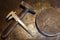 The old steel hammer with wooden handle, iron heavy ring and calipers on the metal background