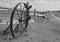 Old steel spoked wheel leaning on a log fine. black and white