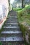 Old steep stairway uphill in rock, long endless. path that runs along the gardens