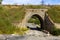 old stone arch under the railway bridge in the Chelyabinsk region on a summer sunny day.