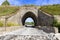 old stone arch under the railway bridge in the Chelyabinsk region on a summer sunny day.