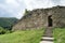 Old stone arched door of ruined ancient castle at Cisnadioara fortress in Sibiu,  Romania. Stone wall fortress with stairs leading