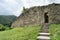 Old stone arched door of ruined ancient castle at Cisnadioara fortress in Sibiu,  Romania. Stone wall fortress with stairs leading