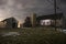 Old stone barn with silo and shed on a foggy night