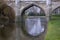 Old stone bridge arches with moat in England