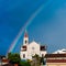 Old stone church with rainbow in sky in Dalmatia, Croatia