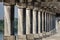 Old stone columns. Ancient colonnade. Corridor with columns