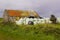 An old stone cottage with a rusting corrugated iron roof in Northern Ireland that has been converted for farm storage uses