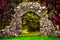 Old stone entrance wall in the garden with colorful foliage