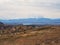 An old stone guest house high in the mountains against the backdrop of snowy majestic peaks. Difficult natural conditions of