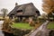 old stone house with a thatched roof in a picturesque setting