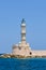 An old stone lighthouse guarding the entrace to a port Chania, Crete, Greece