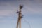 Old stone pillar with wires on the blue sky background. Soft dreamy image