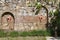 Old stone structure with urns built into a stone wall in the gardens of a restaurant in Turkey