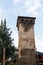 Old stone svan tower on street of Mestia city in Svaneti, Georgia. Sky with clouds background.
