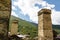 Old stone svan towers on street of Ushguli village in Svaneti, Georgia. Sunny day and sky with clouds background.