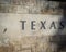 Old stone texture of Texas with a comma word on wall brick