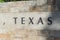 Old stone texture of Texas with a comma word on wall brick