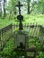 Old stone tombstone and a metal cross at the Orthodox cemetery.