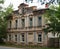 Old stone tumbledown house in russian provincial town at sunset