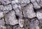 old stone wall fence protective facade weather-beaten broken rough boulder base gray close-up