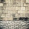 Old stone wall and gray cobblestone pavement