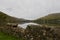 An old stone wall looks out onto a quiet lake in rural Connemara in western Ireland