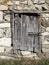 Old stone wall with wooden padlocked door