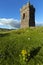 An old stone Watch tower over looking Dingle Bay Co. Kerry Ireland as a fishing boat heads out to sea.