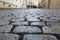 An old stoneblock pavement cobbled with rectangular granite blocks with crushed rock fines between blocks as a background